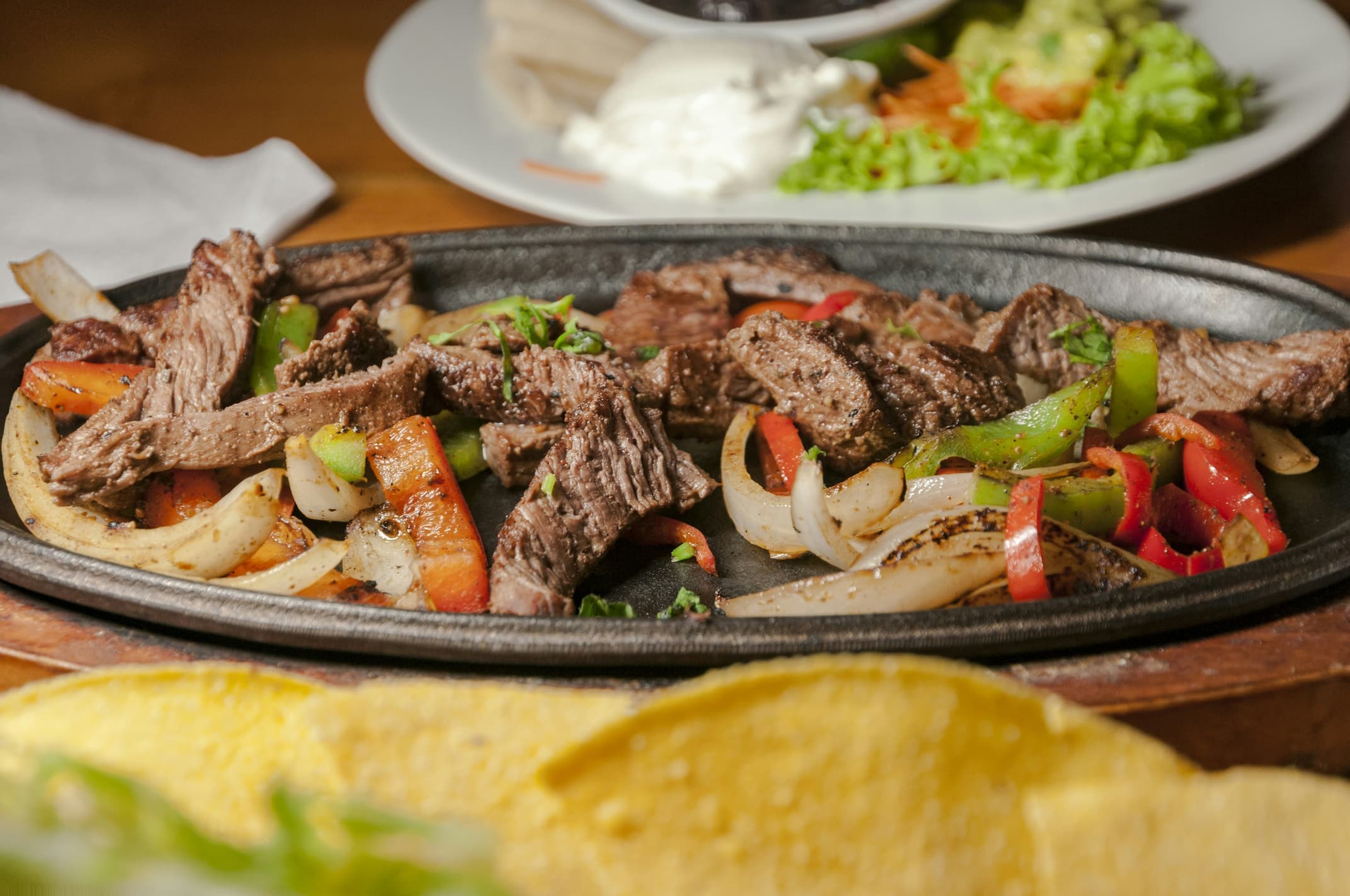Sizzling steak fajitas with grilled peppers and onions